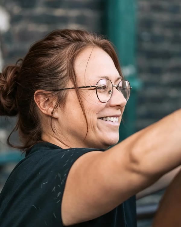 Tanja Witte lacht, während sie den Hals eines Pferdes abtastet